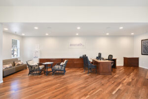 Interior Leasing Office, rattan furniture, wood floors, white walls.
