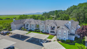 Aerial Exterior of bay vista at meadow park, trees scattered throughout the property, sprawling hills in the distance.